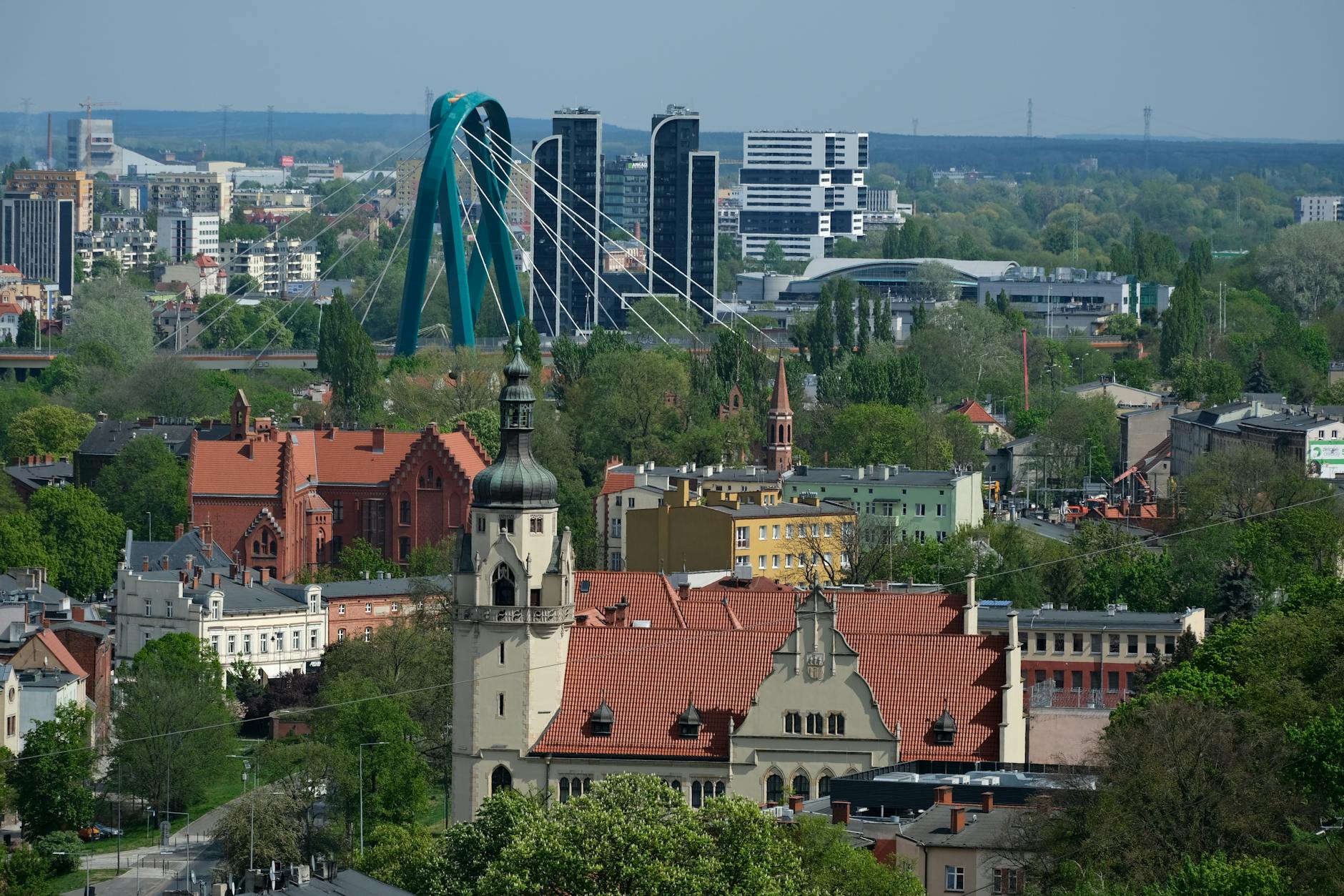 Ilustracja przedstawiająca kontrast i jednocześnie harmonię – symbole duchowości i zabawy na tle panoramy Lubina.